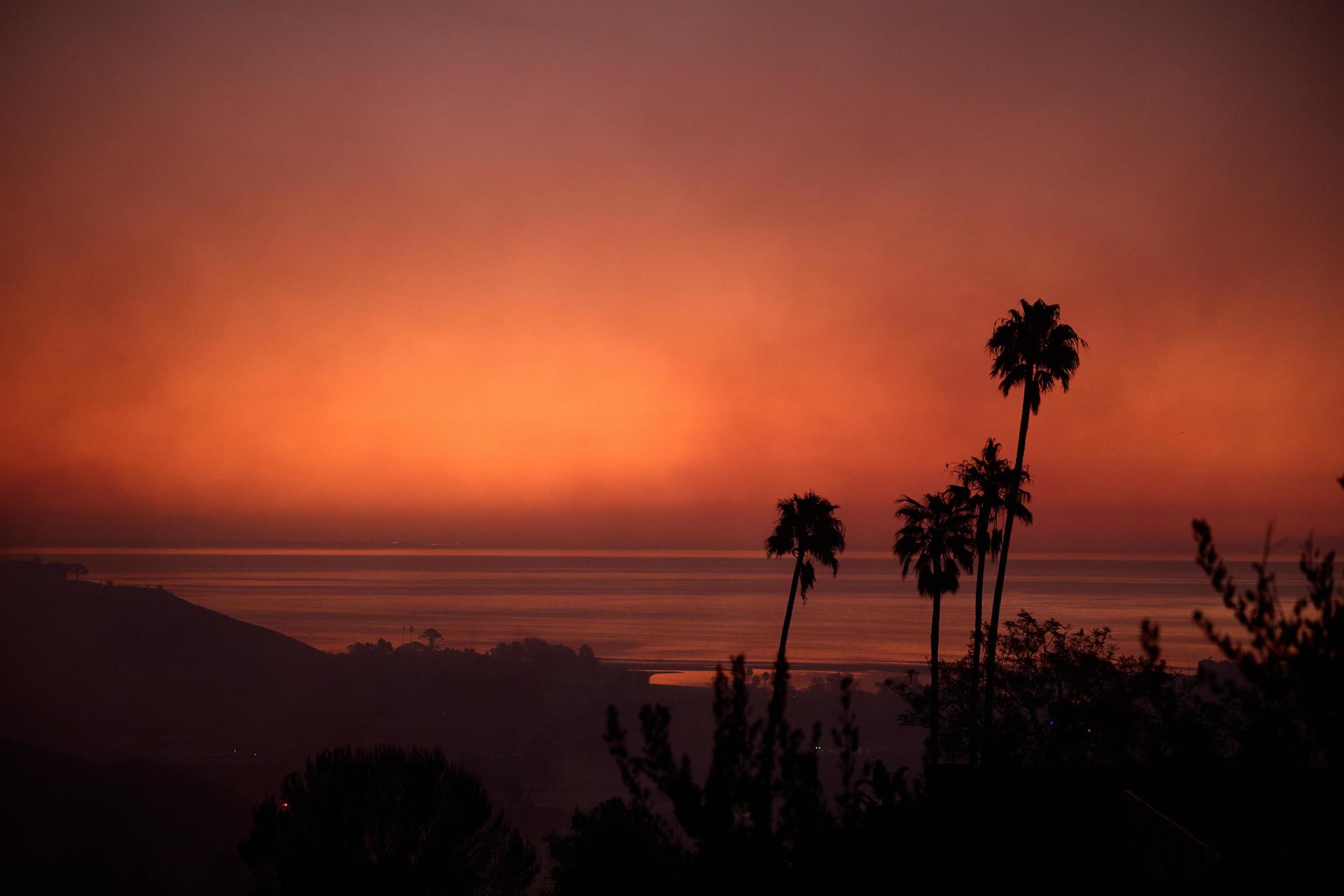 Fotografía de archivo que muestra al sol que sale mientras un incendio forestal, denominado "incendio Franklin" por las autoridades, arde en Malibú, California, EE. UU., el 10 de diciembre de 2024.EFE/EPA/Allison Dinner