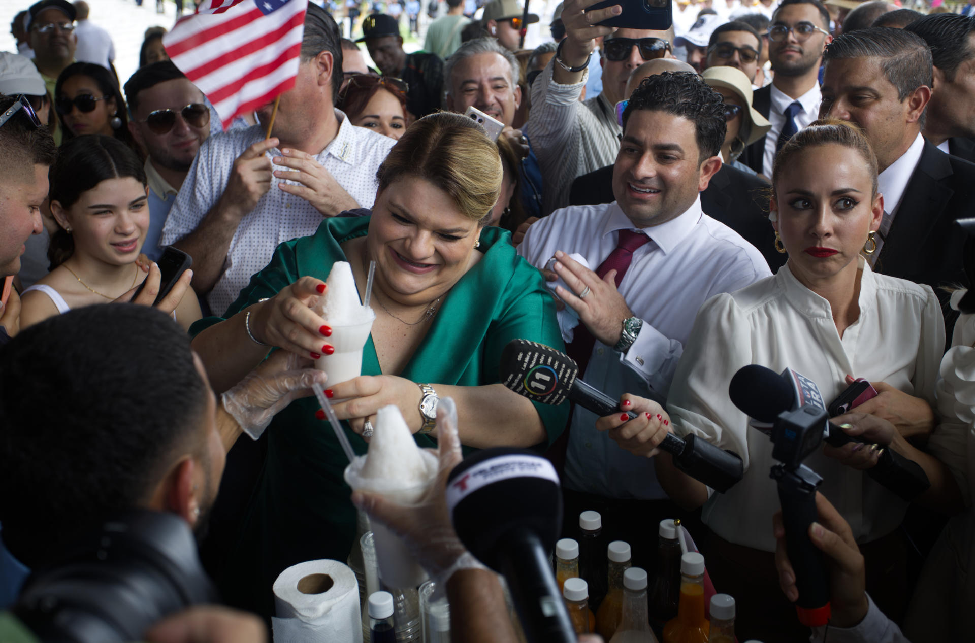 Fotografía de archivo del pasado 2 de enero de la gobernadora de Puerto Rico Jenniffer González (i) mientras recibe un limber (paleta helada) de coco luego de su investidura frente al Capitolio en San Juan (Puerto Rico). EFE/ Thais Llorca