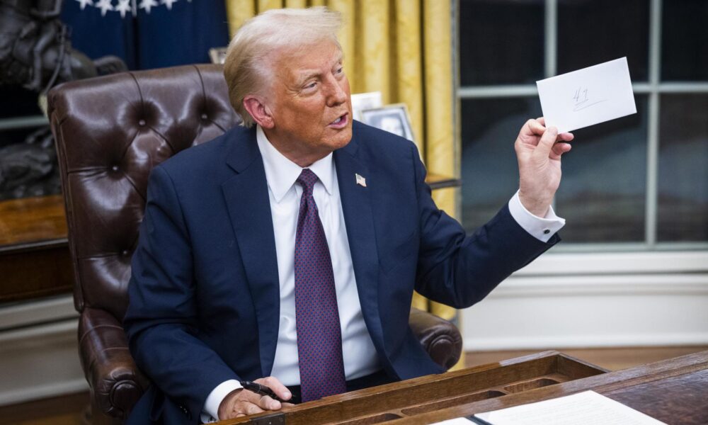 El presidente Donald Trump sostiene una carta que le dejó el expresidente Joe Biden en el cajón del escritorio Resolute el primer día de su presidencia en la Oficina Oval de la Casa Blanca en Washington, DC (EE.UU.). EFE/JIM LO SCALZO / POOL