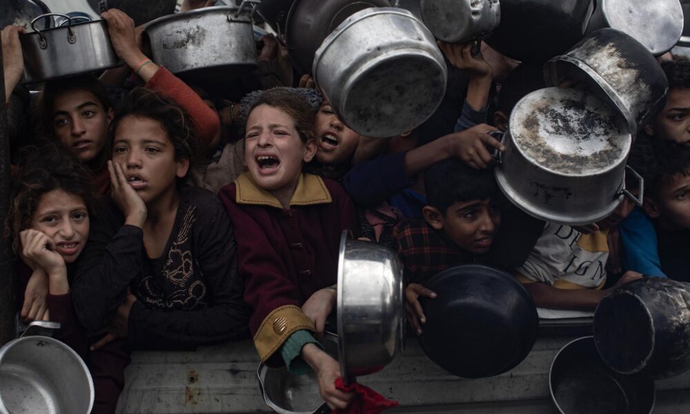 Niños palestinos sostienen ollas para recibir comida de una cocina benéfica en Jan Yunis, en el sur de la Franja de Gaza, el 29 de noviembre de 2024. EFE/EPA/HAITHAM IMAD