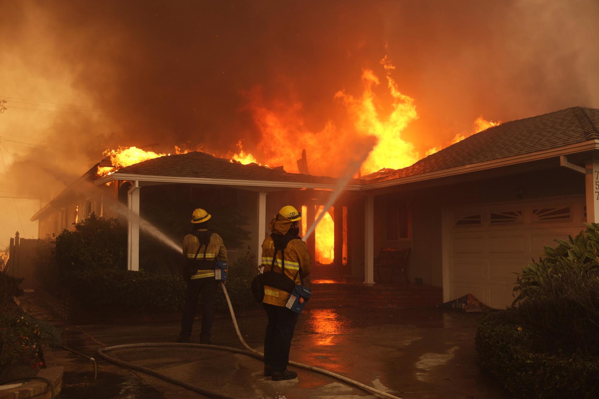 Imagen de archivo que muestra a bomberos combatiendo un incendio que envuelve una vivienda durante el incendio de Palisades, en el vecindario de Pacific Palisades, Los Ángeles, California, EE.UU. EFE/EPA/ALLISON DINNER