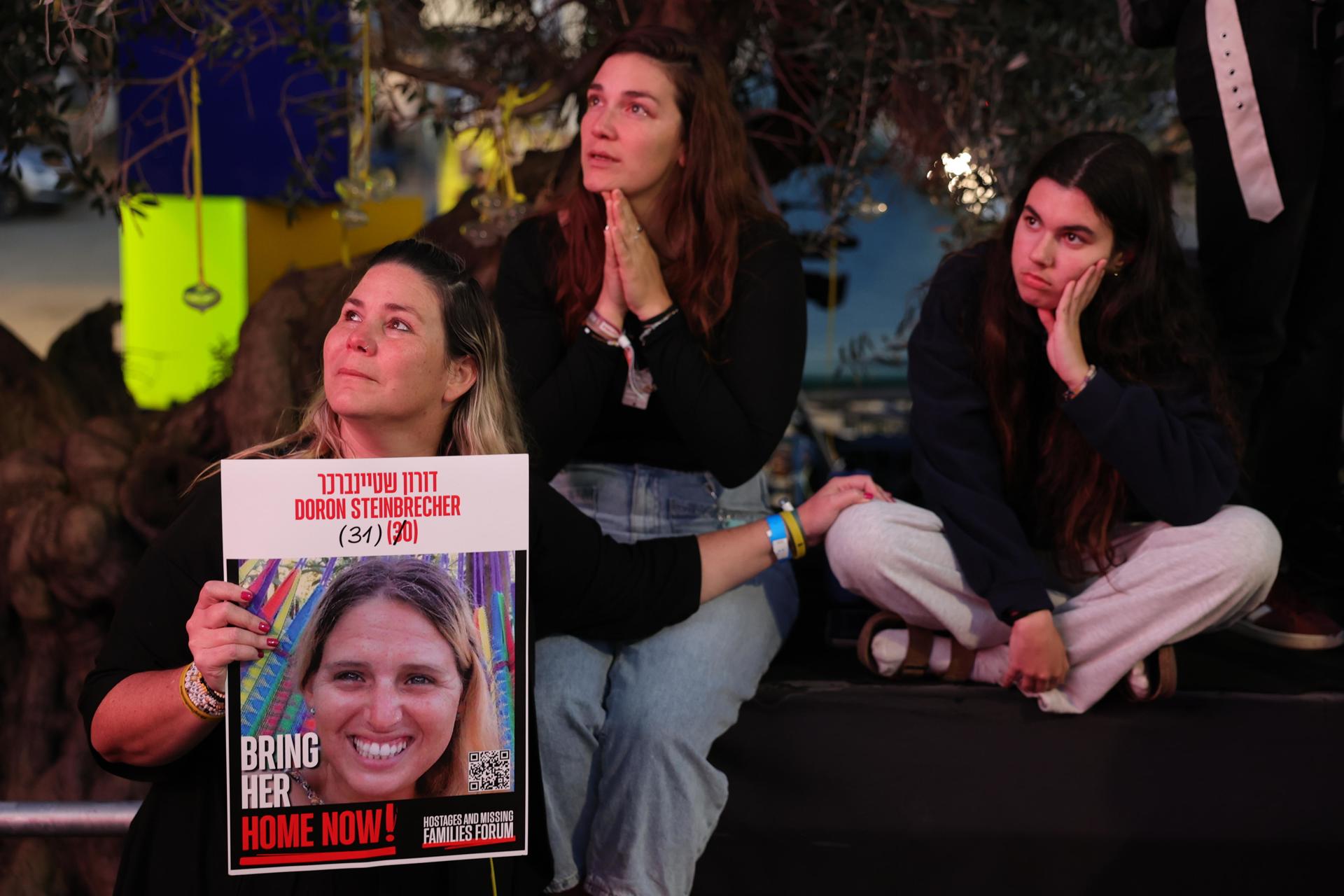 Frontera de Gaza (Israel) (EFE).- Varias personas observan una transmisión en vivo en una pantalla grande que informa sobre la liberación de tres rehenes israelíes, Romi Gonen, Emily Damari y Doron Steinbrecher, transferidos de Hamás a la Cruz Roja. EFE/EPA/ABIR SULTAN