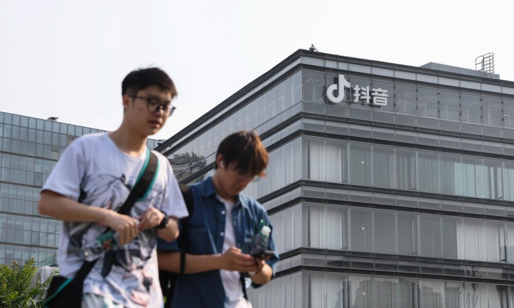 Fotografía de archivo en donde se ven dos jóvenes caminan frente a las oficinas de ByteDance, matriz de TikTok, en Pekín (China). EFE/ WU HAO