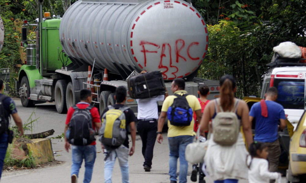 Fotografía de archivo del 16 de agosto de 2023 de personas caminando junto a un camión con la frase "FARC 33" en la Vereda Santa Rosa, en Catatumbo (Colombia). EFE/ Mario Caicedo