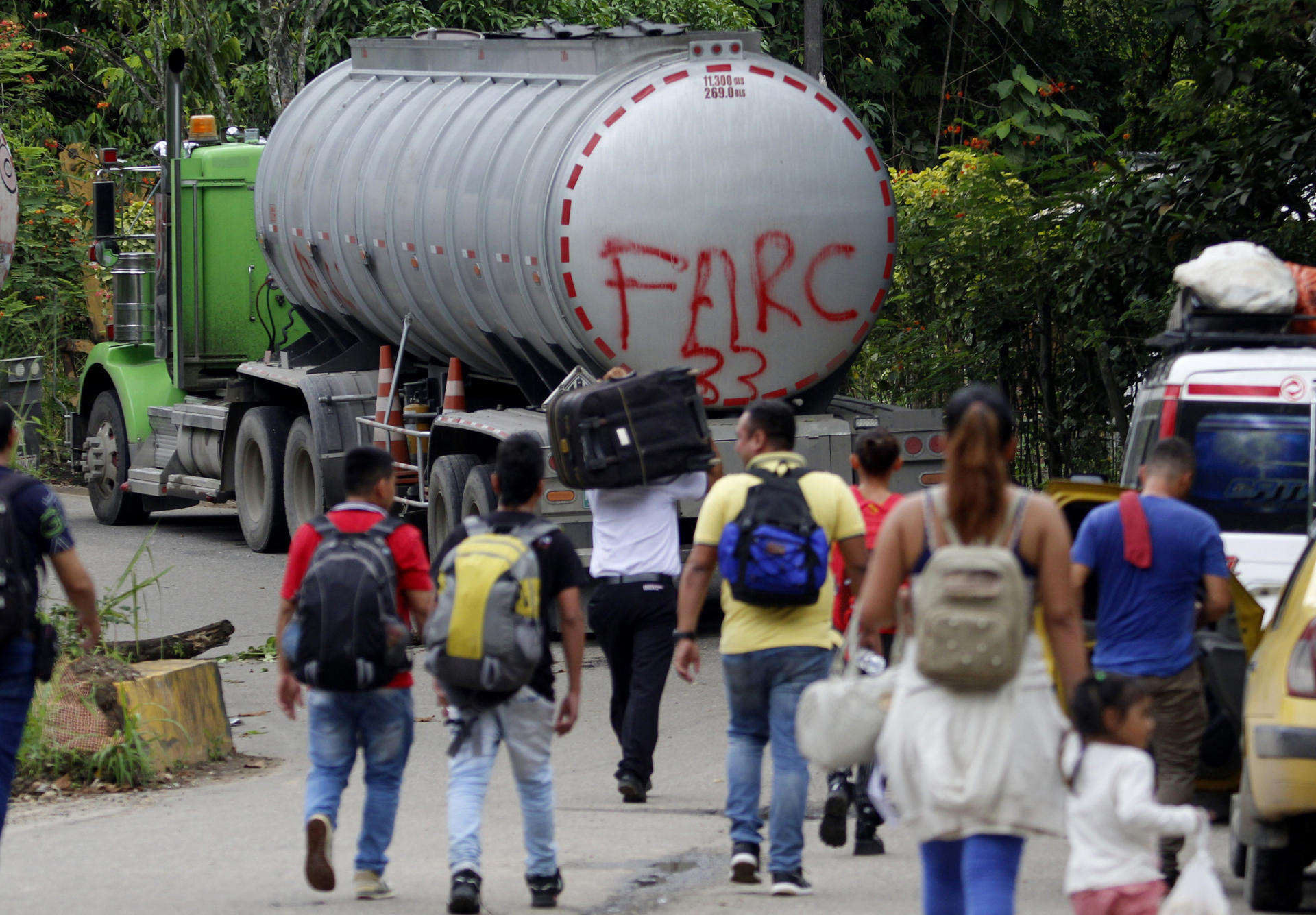 Fotografía de archivo del 16 de agosto de 2023 de personas caminando junto a un camión con la frase "FARC 33" en la Vereda Santa Rosa, en Catatumbo (Colombia). EFE/ Mario Caicedo