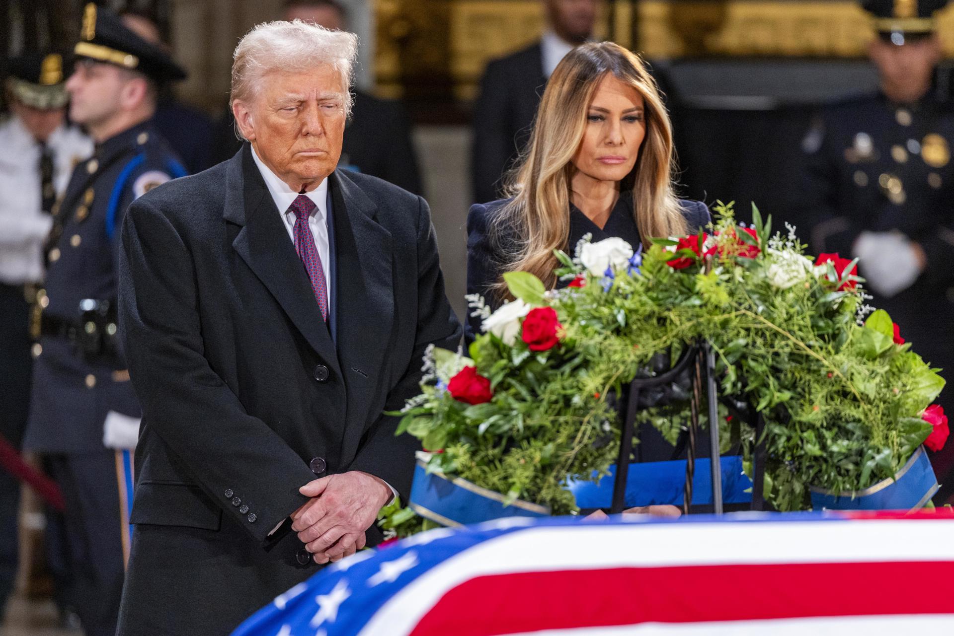 El presidente electo de Estados Unidos, Donald J. Trump, y Melania Trump se detienen ante el ataúd envuelto en la bandera del expresidente estadounidense Jimmy Carter mientras yace en la Rotonda del Capitolio de Estados Unidos en Washington, DC, EE. UU., el 8 de enero de 2025. EFE/EPA/Shawn Thew