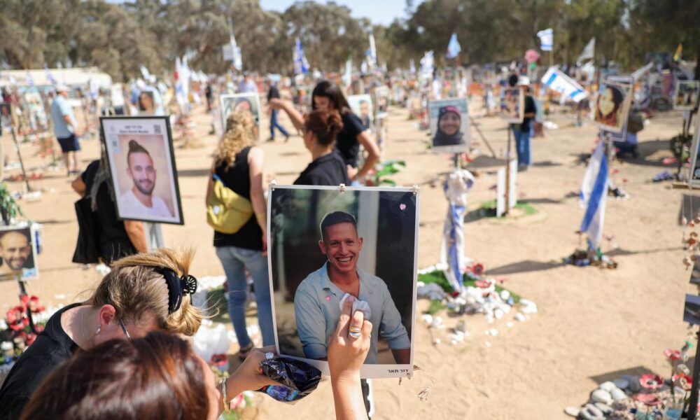 Una mujer limpia una foto de un familiar y memoriales para los asistentes israelíes al festival que fueron asesinados por Hamas en el lugar del rave del Supernova Music Festival cerca de Kibbutz Reim, Sur de Israel. EFE/ABIR SULTAN