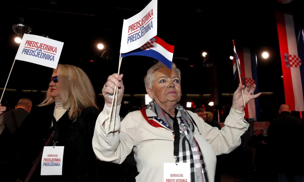 Partidarias de Zoran Milanovic muestran banderines con el letrero "Presidente para presidente" durante una fiesta en Zagreb tras la segunda vuelta de las elecciones presidenciales en Coracia. EFE/EPA/Antonio Bat