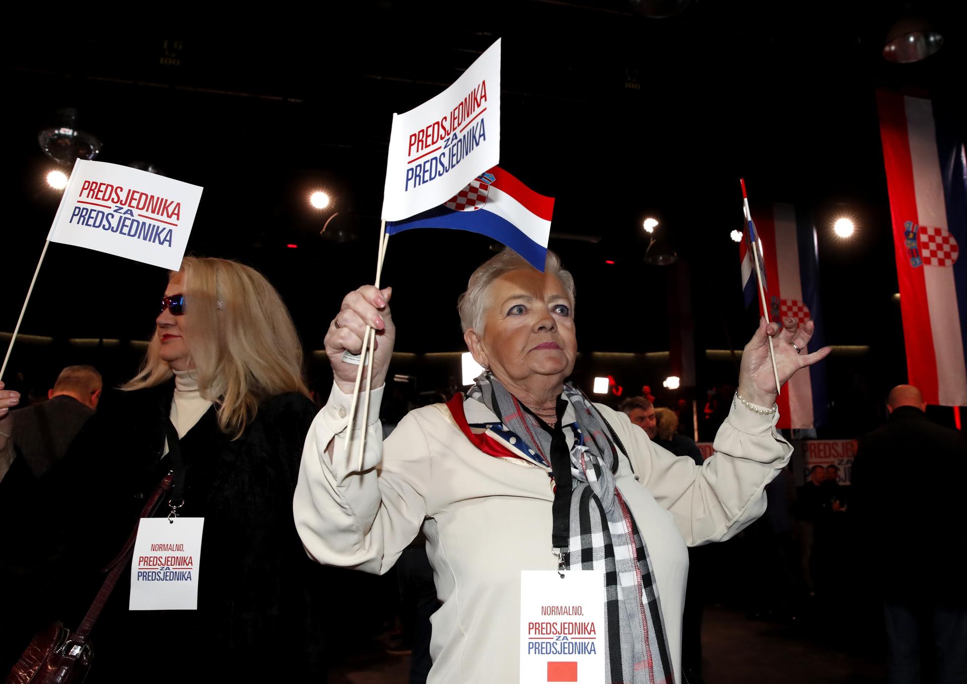 Partidarias de Zoran Milanovic muestran banderines con el letrero "Presidente para presidente" durante una fiesta en Zagreb tras la segunda vuelta de las elecciones presidenciales en Coracia. EFE/EPA/Antonio Bat