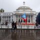 Unas personas con banderas nacionales caminan frente al Capitolio, de la Cámara de Representantes y el Senado, en San Juan (Puerto Rico). Archivo. EFE/Thais Llorca