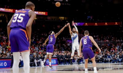 El base de los Atlanta Hawks, Trae Young (2d), lanza este miércoles por tres puntos a pesar de la marca en bloque de Kevin Durant (i), Bradley Beal (2-I) y Grayson Allen (D) de los Phoenix Suns durante el juego celebrado en Atlanta (Georgia). EFE/EPA/ERIK S. LESSER