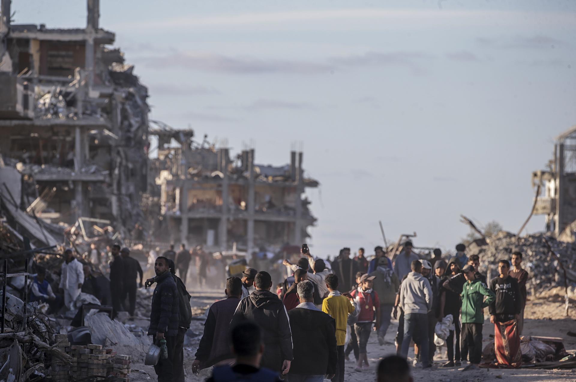 Imagen de 20 de enero de 2025 de palestinos en una calle destruída por los bombardeos israelíes en Rafah. EFE/EPA/MOHAMMED SABER