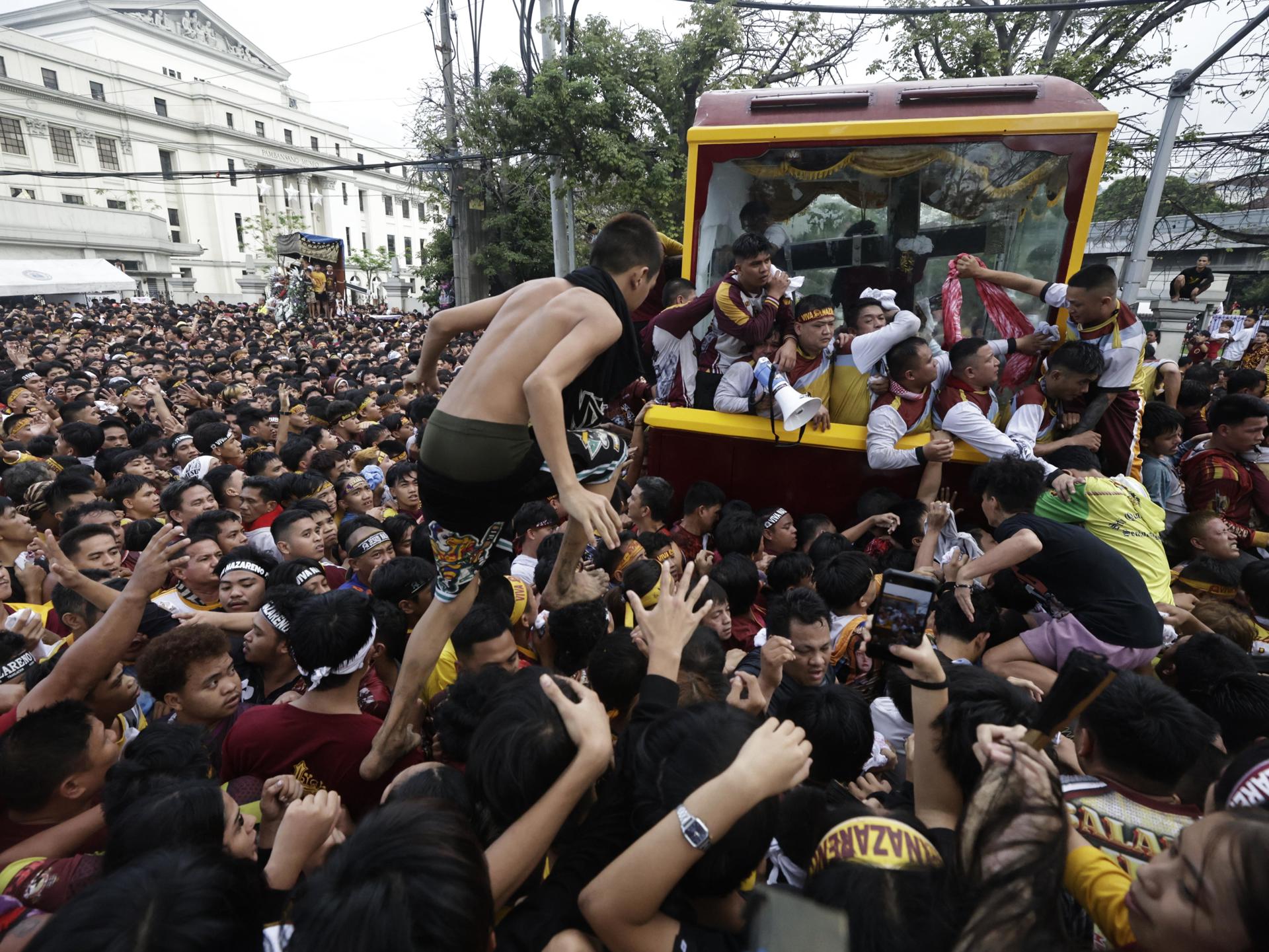 Fieles católicos tratan de acercarse este jueves al Nazareno Negro en la procesión de esta venerada imagen en Manila. EFE/EPA/FRANCIS R. MALASIG