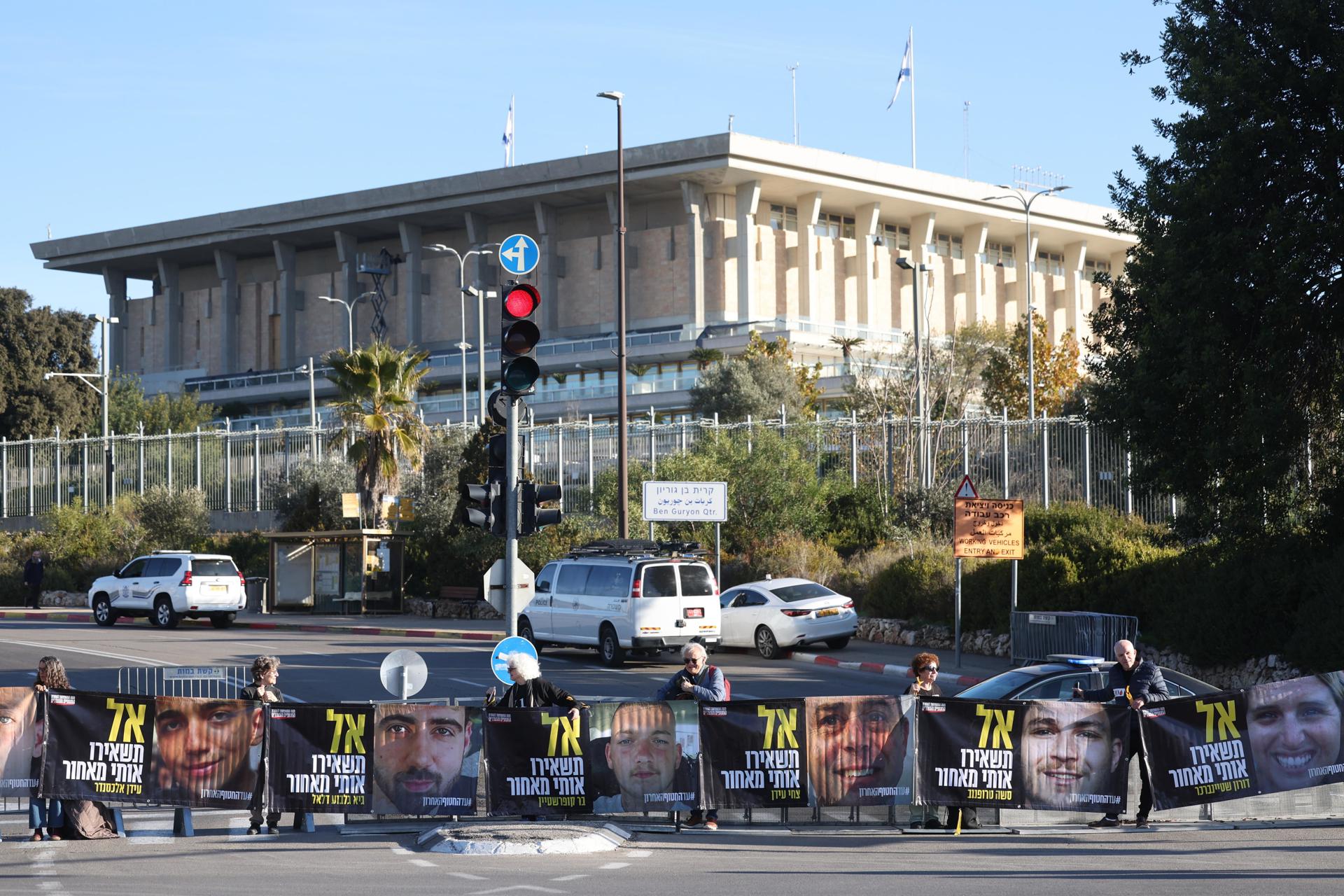 Manifestantes con fotografías de rehenes israelíes retenidos por Hamás en Gaza se manifiestan frente a la Knesset, el Parlamento israelí, pidiendo su liberación, en Jerusalén, el 14 de enero de 2025. EFE/EPA/ABIR SULTAN