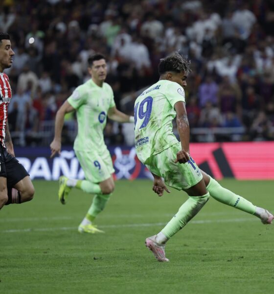 El delantero del FC Barcelona, Lamine Yamal (d), golpea el balón ante el defensa del Athletic Club, Yuri Berchiche, en la jugada que ha significado el segundo gol del equipo barcelonista durante el partido de semifinales de la Supercopa de España de fútbol que FC Barcelona y Athletic Club disputaron en el estadio Rey Abdullah de Yeda, en Arabia Saudí. EFE/Alberto Estévez.