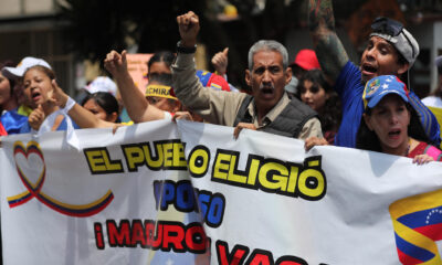 Personas se manifiestan con carteles afuera de la embajada de Venezuela este viernes en Lima (Perú), para seguir manifestando su apoyo al líder antichavista Edmundo González Urrutia. EFE/ Paolo Aguilar