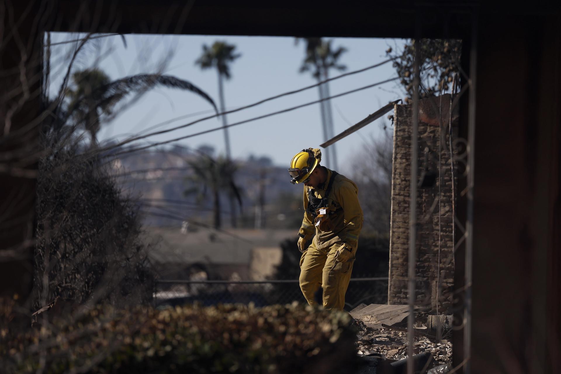 Bomberos y equipos de búsqueda y rescate inspeccionan el lugar de una casa incendiada en Altadena, California, EE.UU.. EFE/EPA/CAROLINE BREHMAN