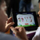 Fotografía de una persona junto a un niño manipulando una tableta en un colegio. EFE/ Paolo Aguilar