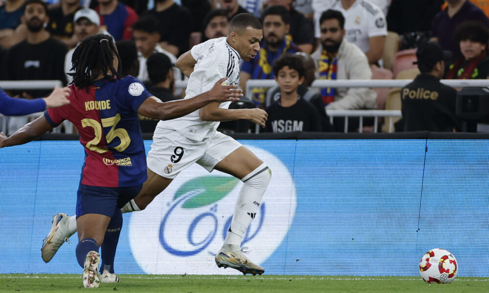 El delantero francés del Real Madrid Kylian Mbappé (d) se escapa de Jules Koundé, del FC Barcelona, durante el partido de la final de la Supercopa de España de fútbol entre el Real Madrid y el FC Barcelona, este domingo en Yeda, Arabia Saudí. EFE/ Alberto Estévez