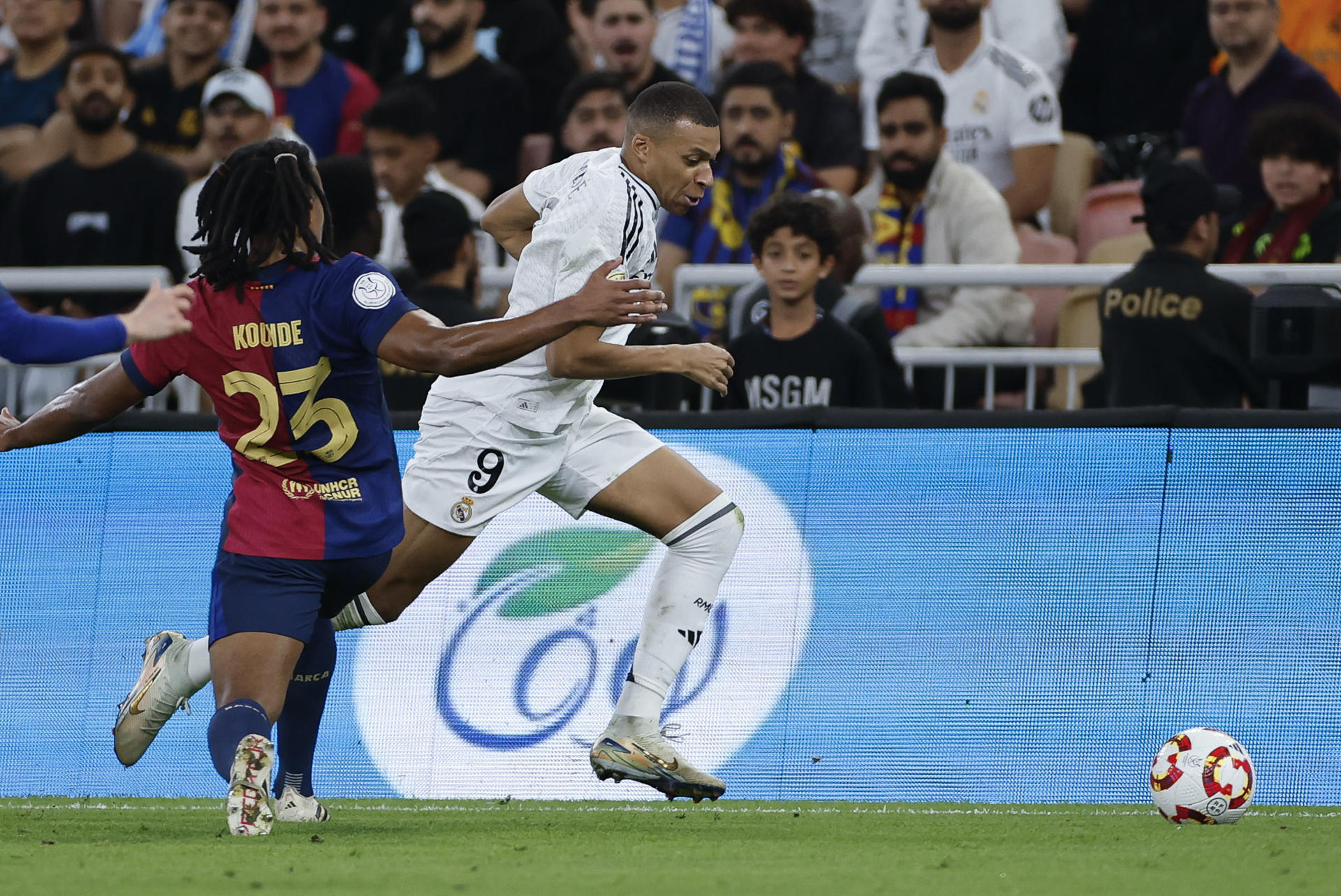 El delantero francés del Real Madrid Kylian Mbappé (d) se escapa de Jules Koundé, del FC Barcelona, durante el partido de la final de la Supercopa de España de fútbol entre el Real Madrid y el FC Barcelona, este domingo en Yeda, Arabia Saudí. EFE/ Alberto Estévez