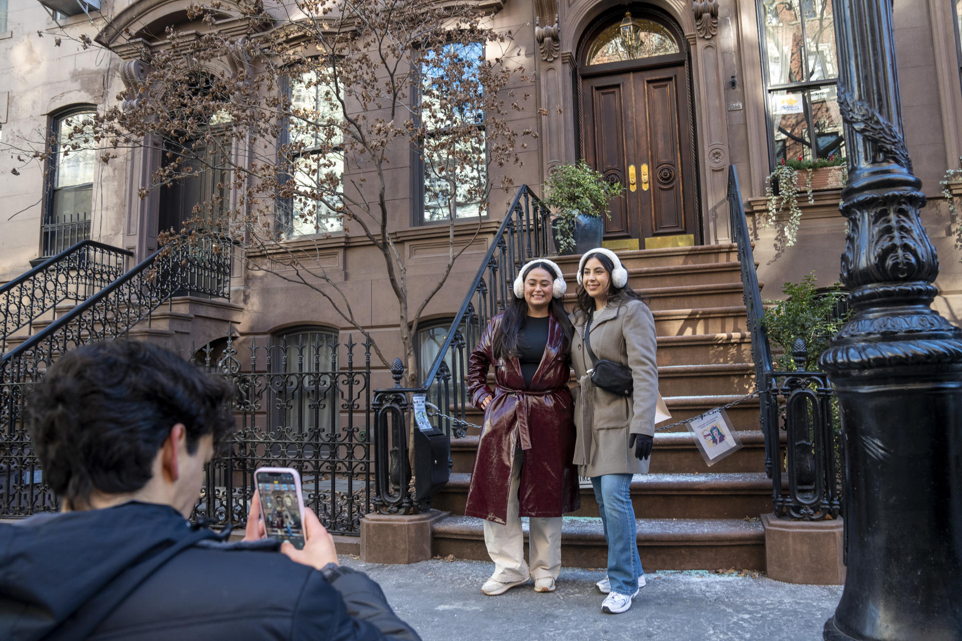 Una pareja de turistas se toma fotos este martes, frente a la casa donde se grabó la serie Sex and the City, en Nueva York (EE.UU.). EFE/ Ángel Colmenares