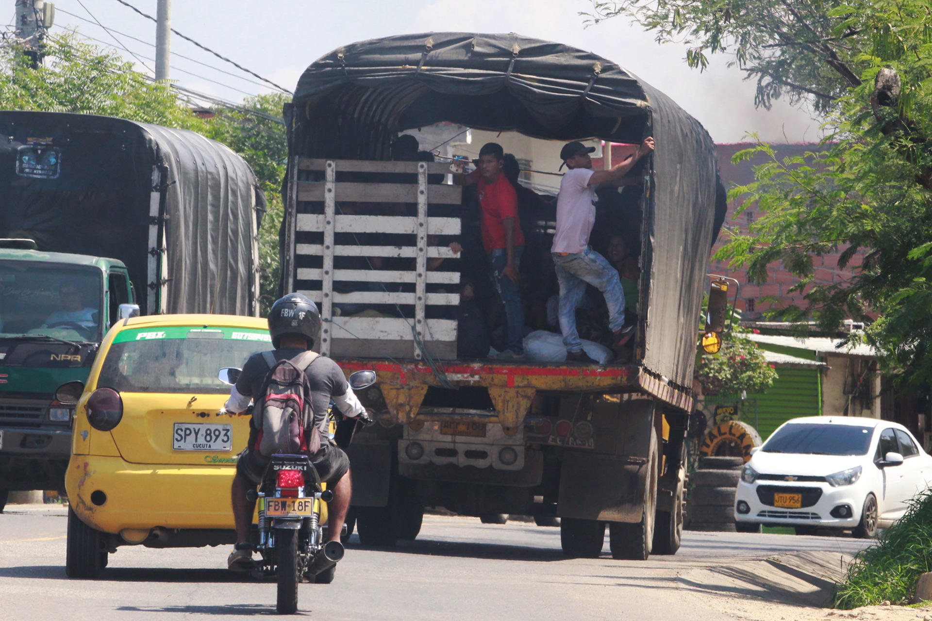 Personas desplazadas por la violencia en la región del Catatumbo se movilizan en una caravana de carros y motos con banderas y globos blancos, buscando llegar este domingo a Cúcuta (Colombia). EFE/ Mario Caicedo