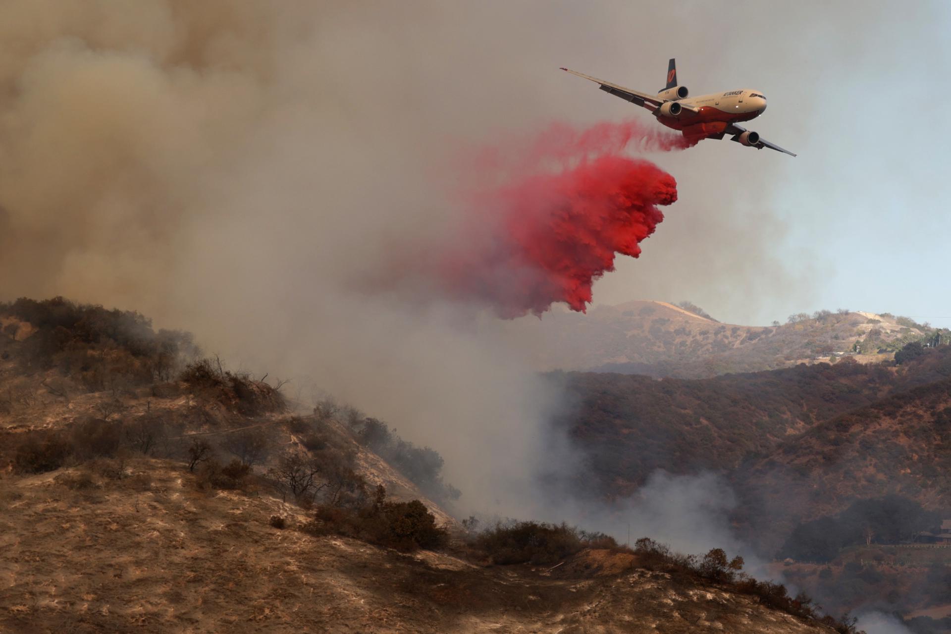 Un avión lanza retardante de fuego contra el incendio forestal de Palisades en Los Ángeles, California (EE.UU.). EFE/ALLISON DINNER