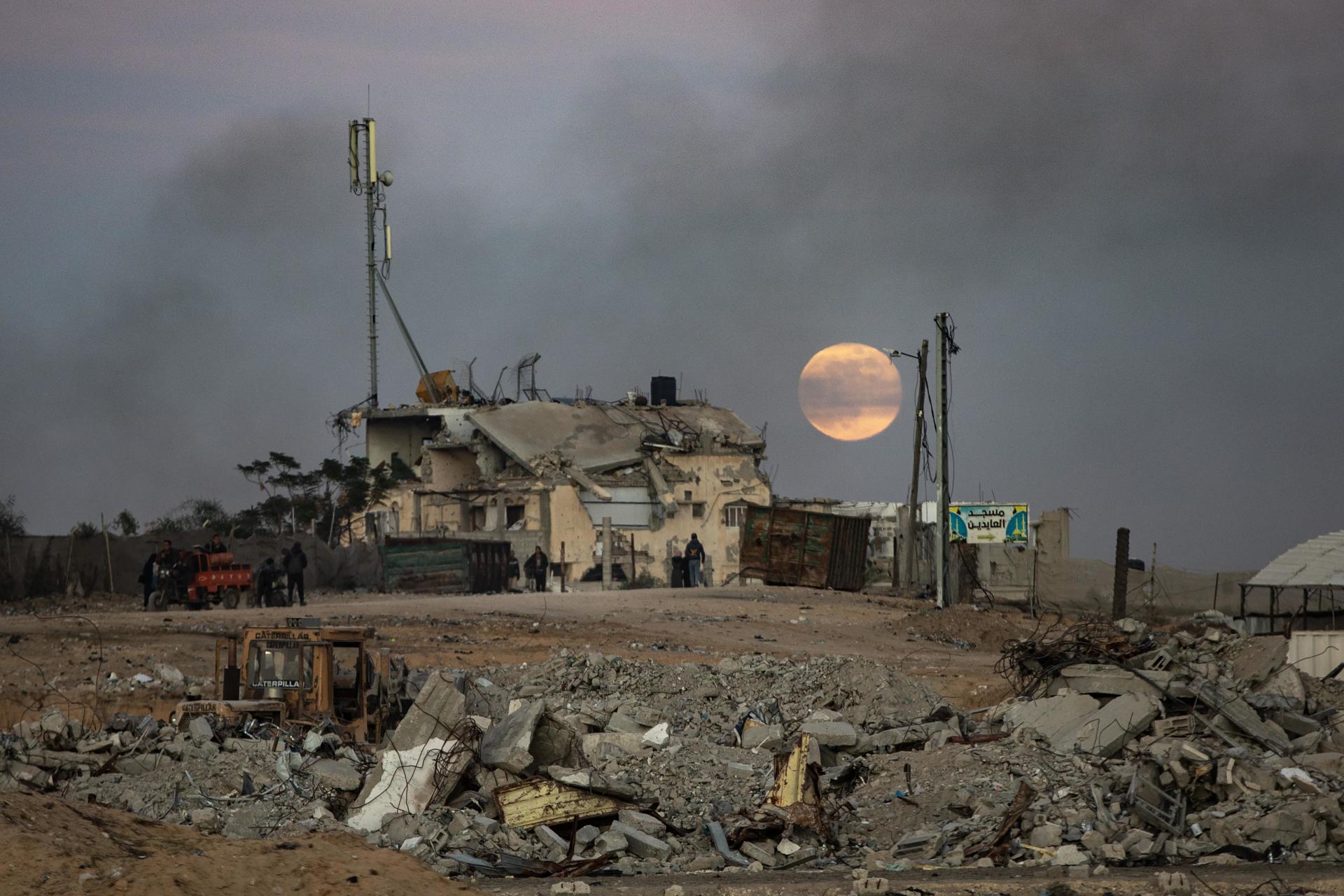 Supervivientes de los bombardeos israelíes huyendo de edificios destruidos en el sur de Gaza. EFE/EPA/HAITHAM IMAD