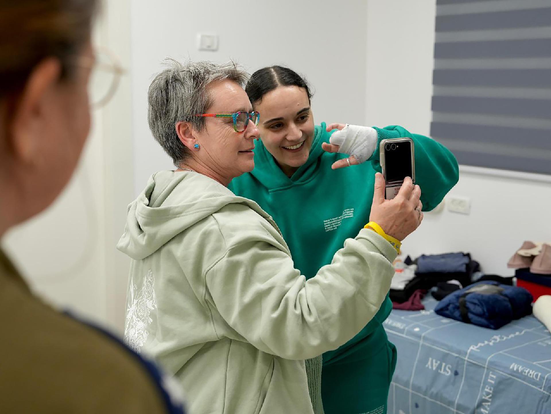 Una foto proporcionada por el ejército israelí muestra a la rehén liberada Emily Damari (D) con su madre Mandy (C) en un punto de recepción cerca del Kibutz Reim, en el sur de Israel, el 19 de enero de 2025. EFE/EPA/IDF COMUNICADO DE PRENSA USO EDITORIAL SOLAMENTE/NO VENTAUSO EDITORIAL SOLAMENTE/NO VENTA