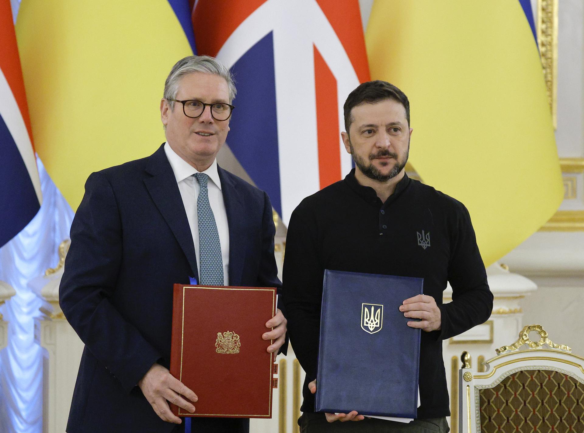 El presidente ucraniano, Volodímir Zelenski (d), y el primer ministro británico, Keir Starmer (i) posan mientras intercambian documentos durante su reunión en Kiev, Ucrania, el 16 de enero de 2025. EFE/EPA/SERGEY DOLZHENKO