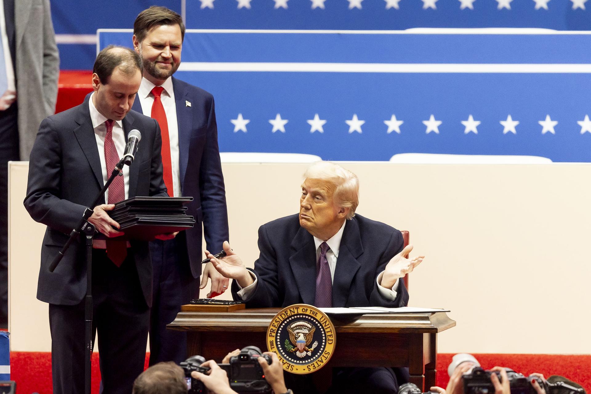 El presidente de Estados Unidos, Donald Trump (c), junto al vicepresidente estadounidense, J.D. Vance (segundo a la izquierda), mientras firma una serie de decretos en el escenario durante un acto inaugural presidencial en el Capitol One Arena en Washington, DC (EE.UU.). EFE/ALLISON DINNER