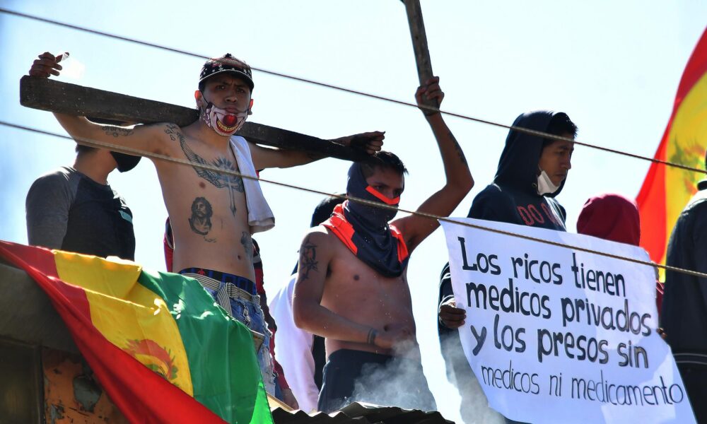 Fotografía de archivo de reos de la cárcel San Sebastián que se amotinan en el techo del penal para exigir con carteles y banderas asistencia médica, en julio de 2020, en Cochabamba (Bolivia). EFE/ Jorge Abrego