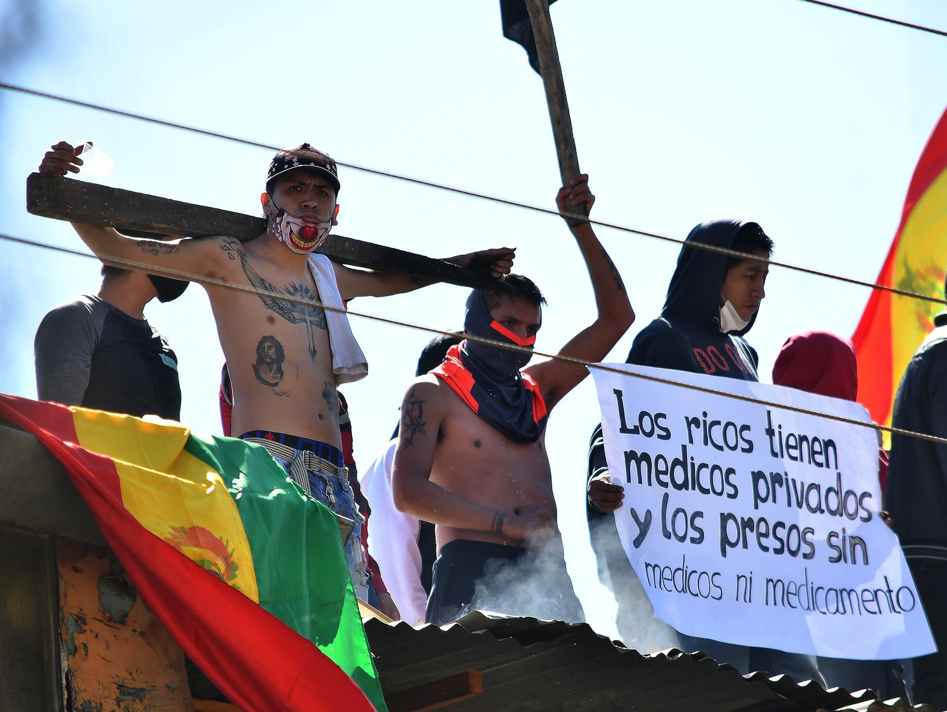 Fotografía de archivo de reos de la cárcel San Sebastián que se amotinan en el techo del penal para exigir con carteles y banderas asistencia médica, en julio de 2020, en Cochabamba (Bolivia). EFE/ Jorge Abrego