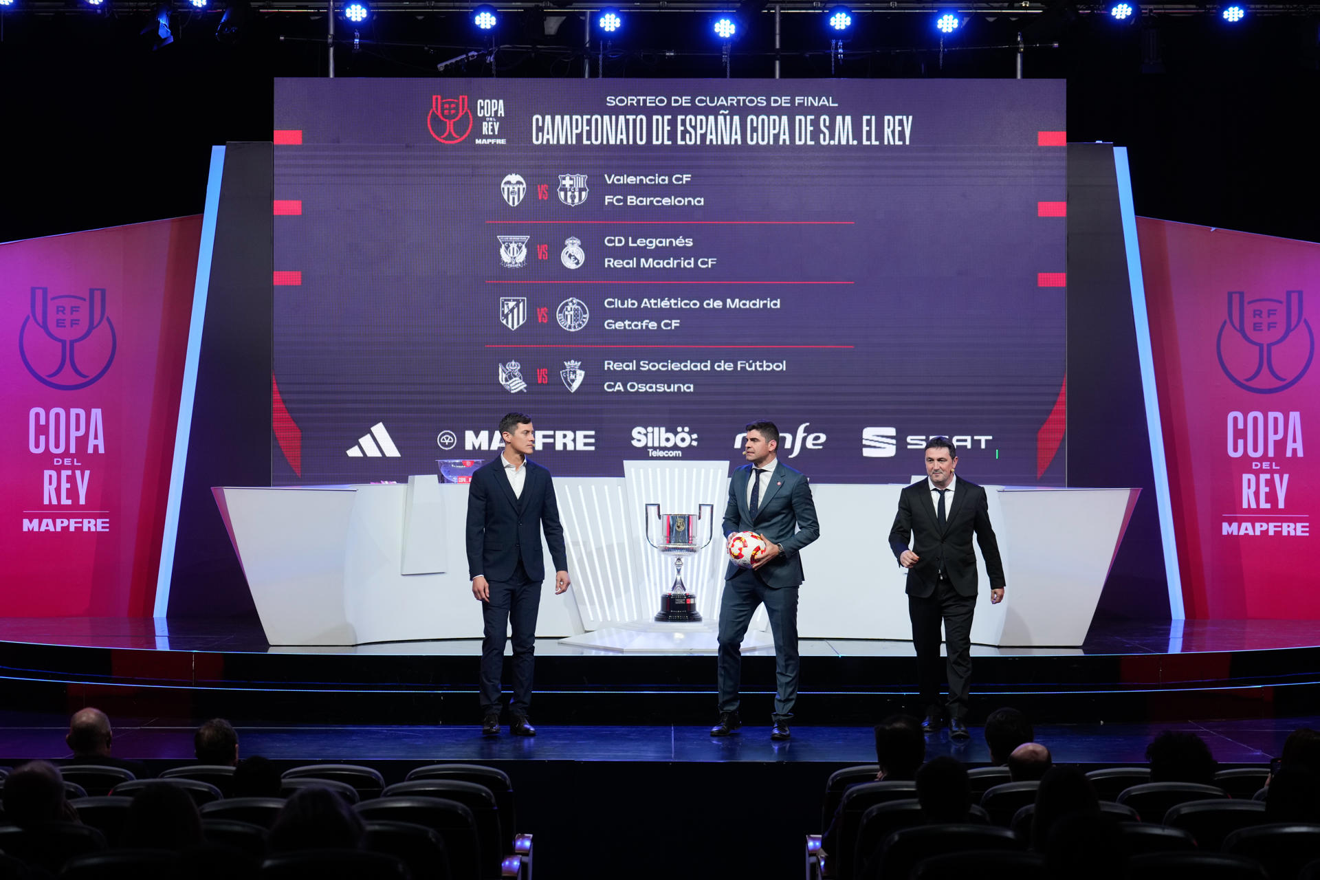 Los exfutbolistas Martín Mantovani (i) y Braulio Vázquez (d) y el periodista Saúl Ramos (c), presentador del evento, durante el sorteo de los cuartos de final de la Copa del Rey celebrado este lunes en la Ciudad del Fútbol de las Rozas (Madrid). EFE/ Borja Sánchez-Trillo