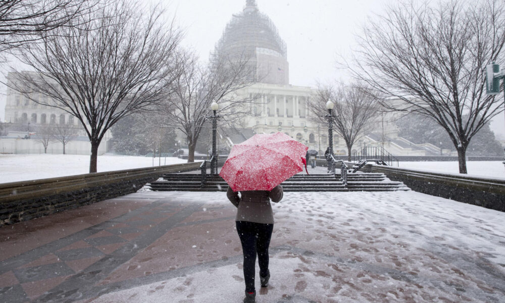 Fotografía de archivo de una mujer en medio de la nieve frente al Capitalio, el 05 de marzo de 2015. EFE/MICHAEL REYNOLDS