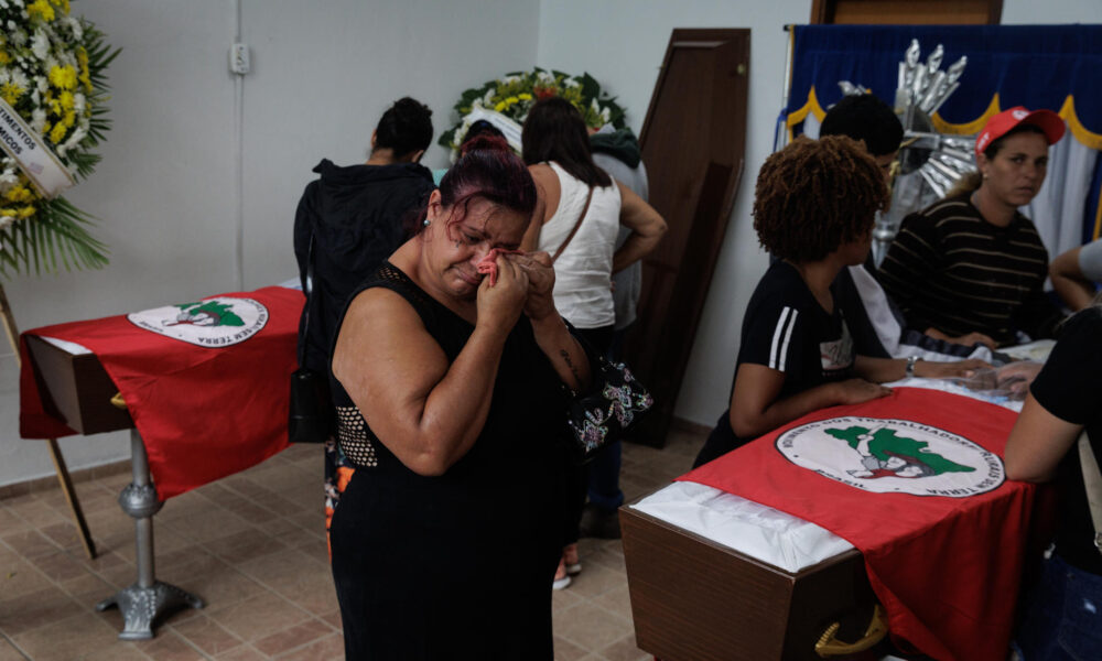 Familiares y amigos de dos miembros del MST (Movimiento de los Sin Tierra) asisten a su velatorio este domingo en Tremembé (Brasil). EFE/ Isaac Fontana