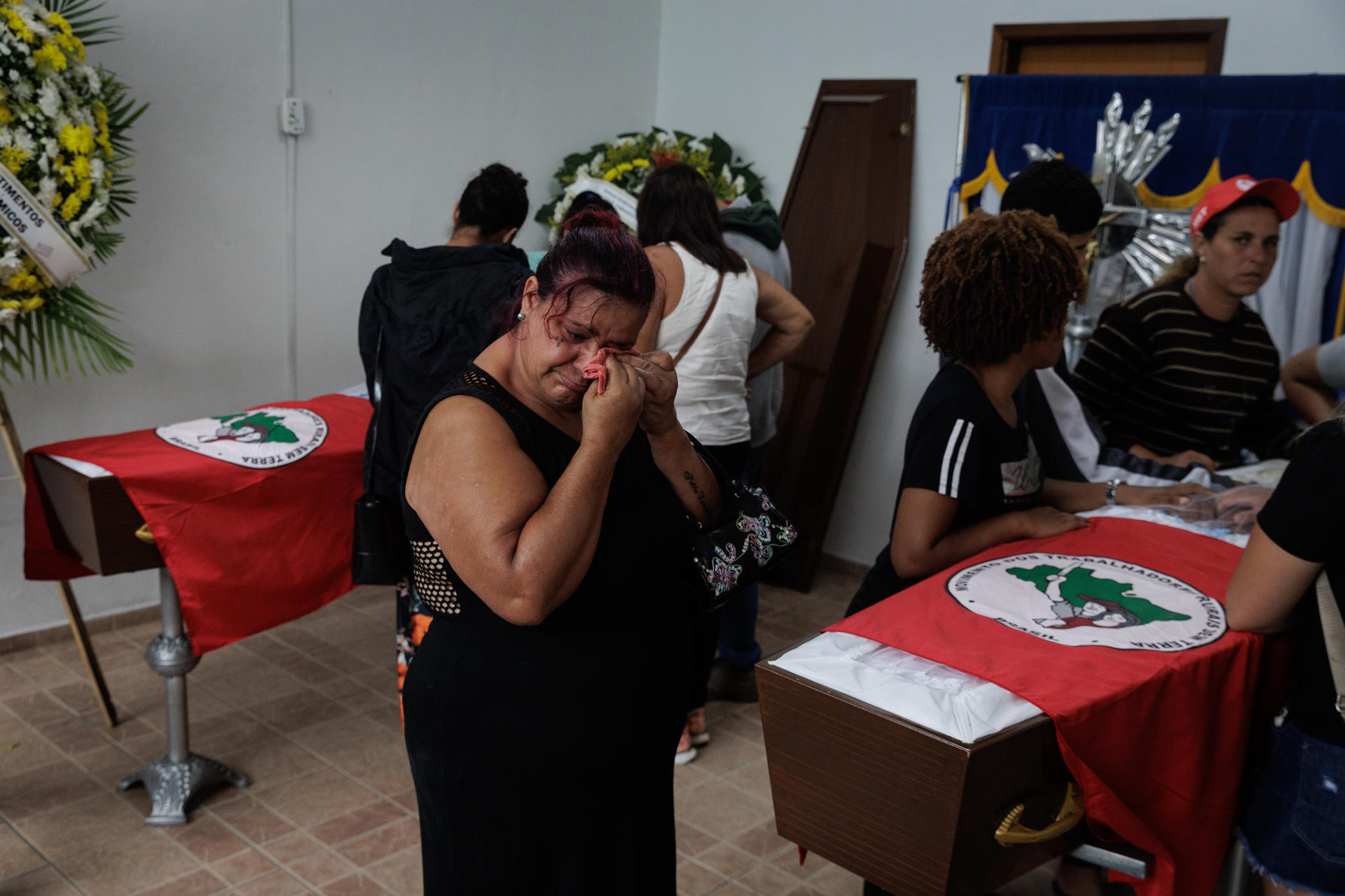 Familiares y amigos de dos miembros del MST (Movimiento de los Sin Tierra) asisten a su velatorio este domingo en Tremembé (Brasil). EFE/ Isaac Fontana