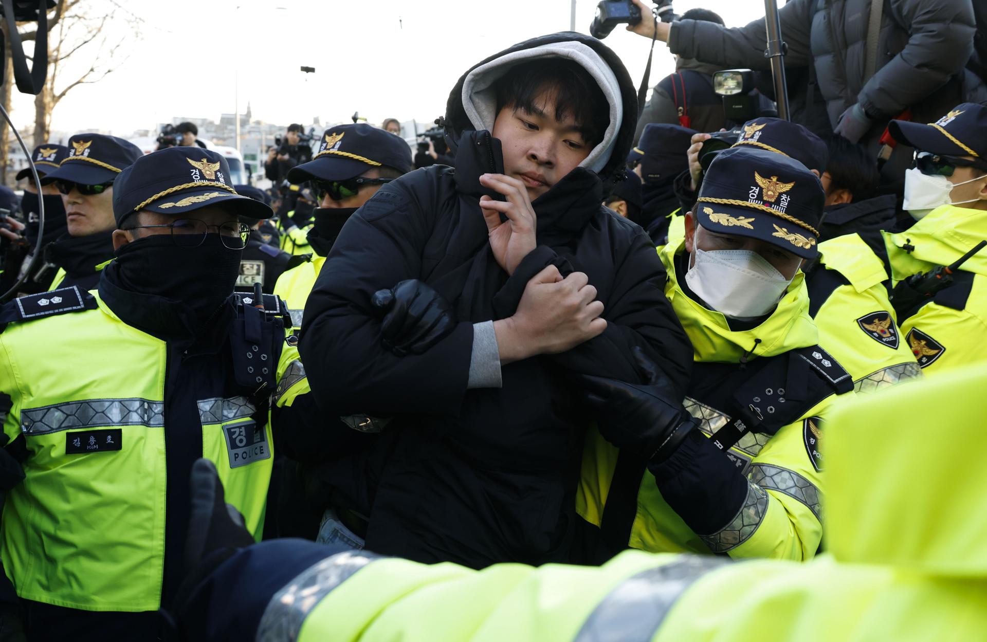 La policía detiene a seguidores del presidente surcoreano Yoon Suk Yeol, quienes se han congregado fuera de la residencia presidencial en un intento por evitar que los investigadores lleven a cabo una orden de arresto en su contra en Seúl, Corea del Sur, 02 de enero de 2025. 
 EFE/EPA/JEON HEON-KYUN