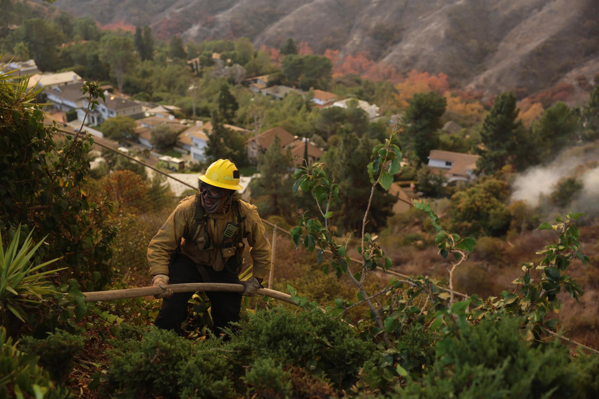 Un bombero trabaja entre la maleza para apagar el incendio forestal de Palisades en Los Ángeles, California (EE.UU.). EFE/ALLISON DINNER