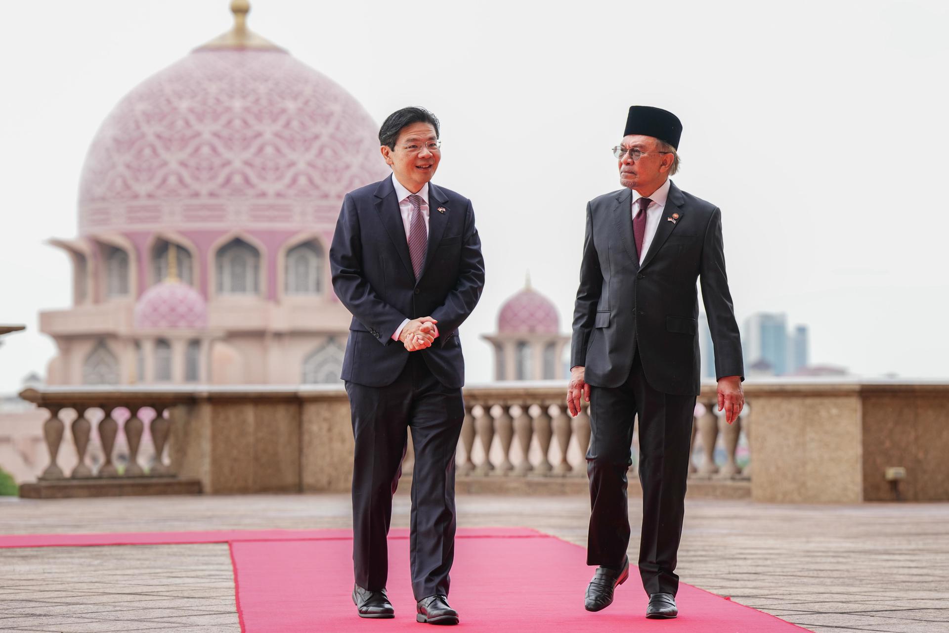 El primer ministro de Singapur, Lawrence Wong camina con su homólogo malasio, Anwar Ibrahim en Putrajaya. EFE/EPA/VINCENT THIAN / POOL