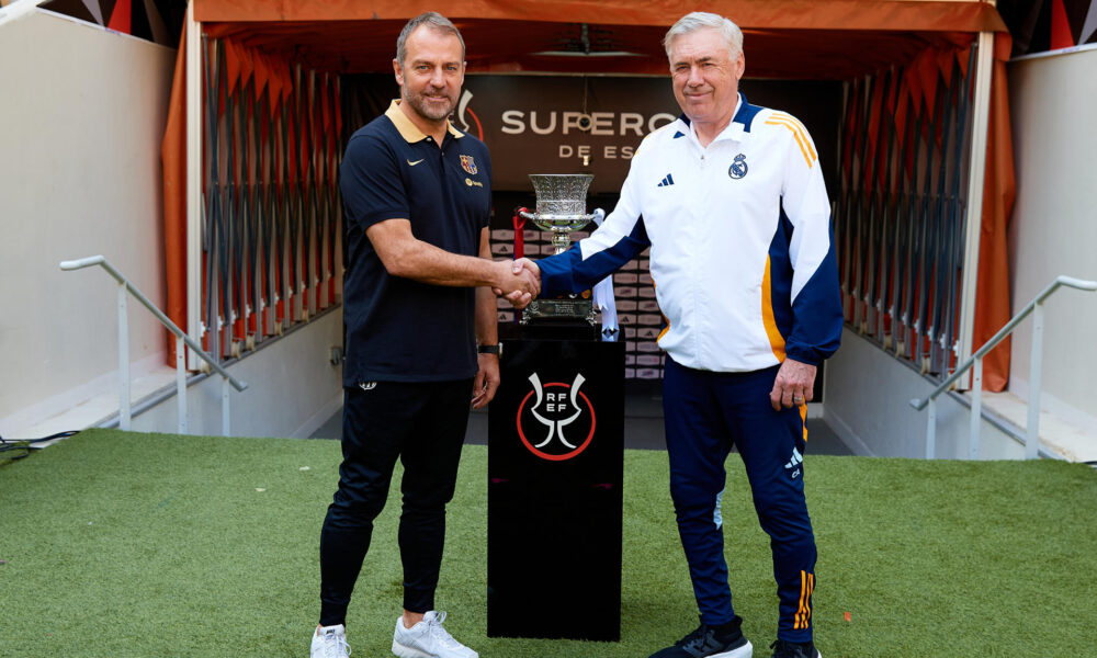 Los entrenadores del Real Madrid CF y el FC Barcelona, Carlo Ancelotti (d) y Hansi Flick (i), respectivamente, han posado este sábado junto al trofeo en el estadio Al Jawhara de Yeda, que mañana acogerá la final de la Supercopa de España. EFE/RFEF/David Aliaga -SOLO USO EDITORIAL/SOLO DISPONIBLE PARA ILUSTRAR LA NOTICIA QUE ACOMPAÑA (CRÉDITO OBLIGATORIO)-