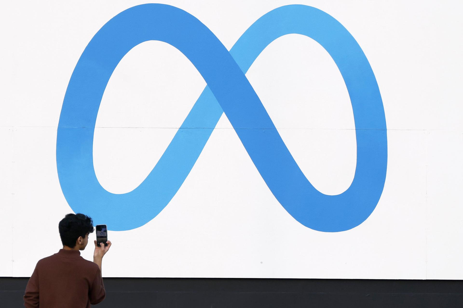 Fotografía de archivo del 7 de enero de 2025 de una persona tomando una fotografía al logo de Meta frente a la sede de la compañía en Menlo Park, California (Estados Unidos). EFE/ John G. Mabanglo