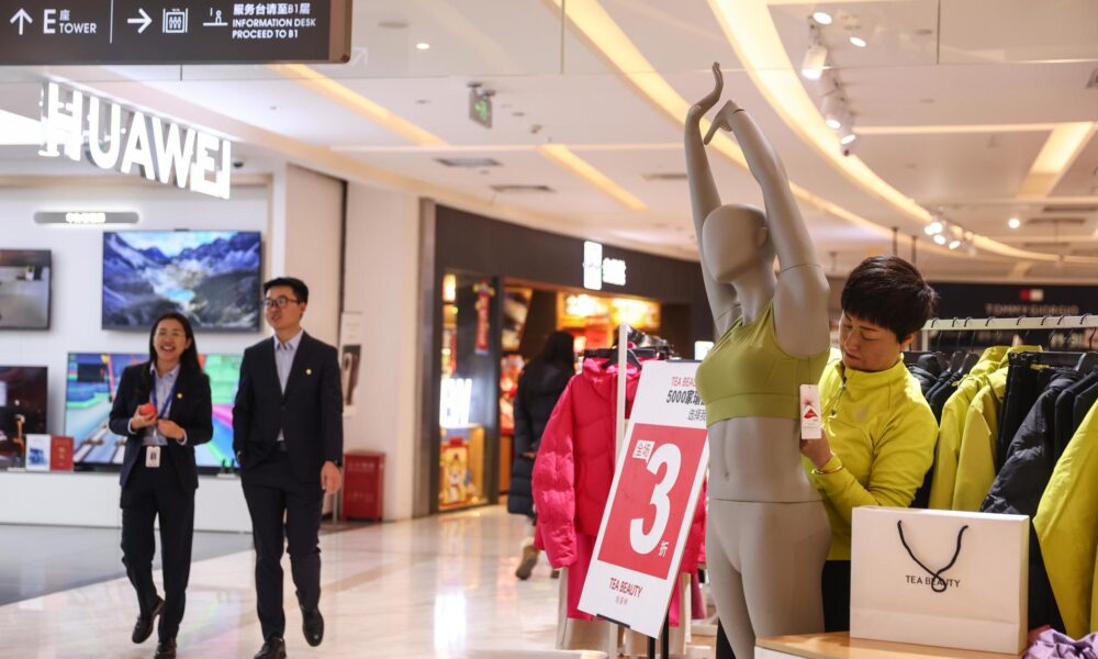 Un vendedor trabaja en una tienda de ropa en un centro comercial en Beijing (China), EFE/EPA/WU HAO