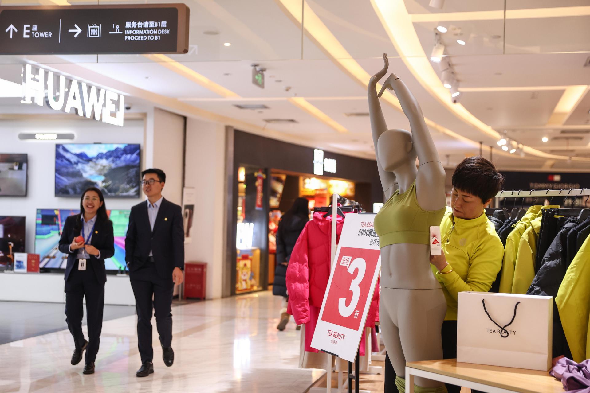 Un vendedor trabaja en una tienda de ropa en un centro comercial en Beijing (China), EFE/EPA/WU HAO