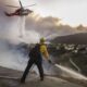 Los bomberos del condado de Los Ángeles utilizan mangueras y lanzan agua desde un helicóptero para combatir el incendio forestal de Palisades en Pacific Palisades, California, (EE.UU.). EFE/CAROLINE BREHMAN