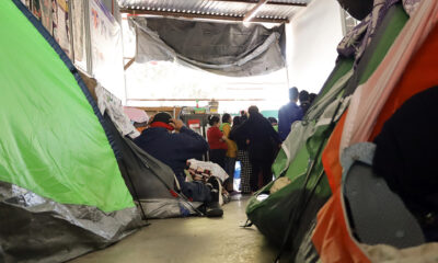 Migrantes descansan en tiendas de campaña en un albergue. EFE/ Joebeth Terríquez