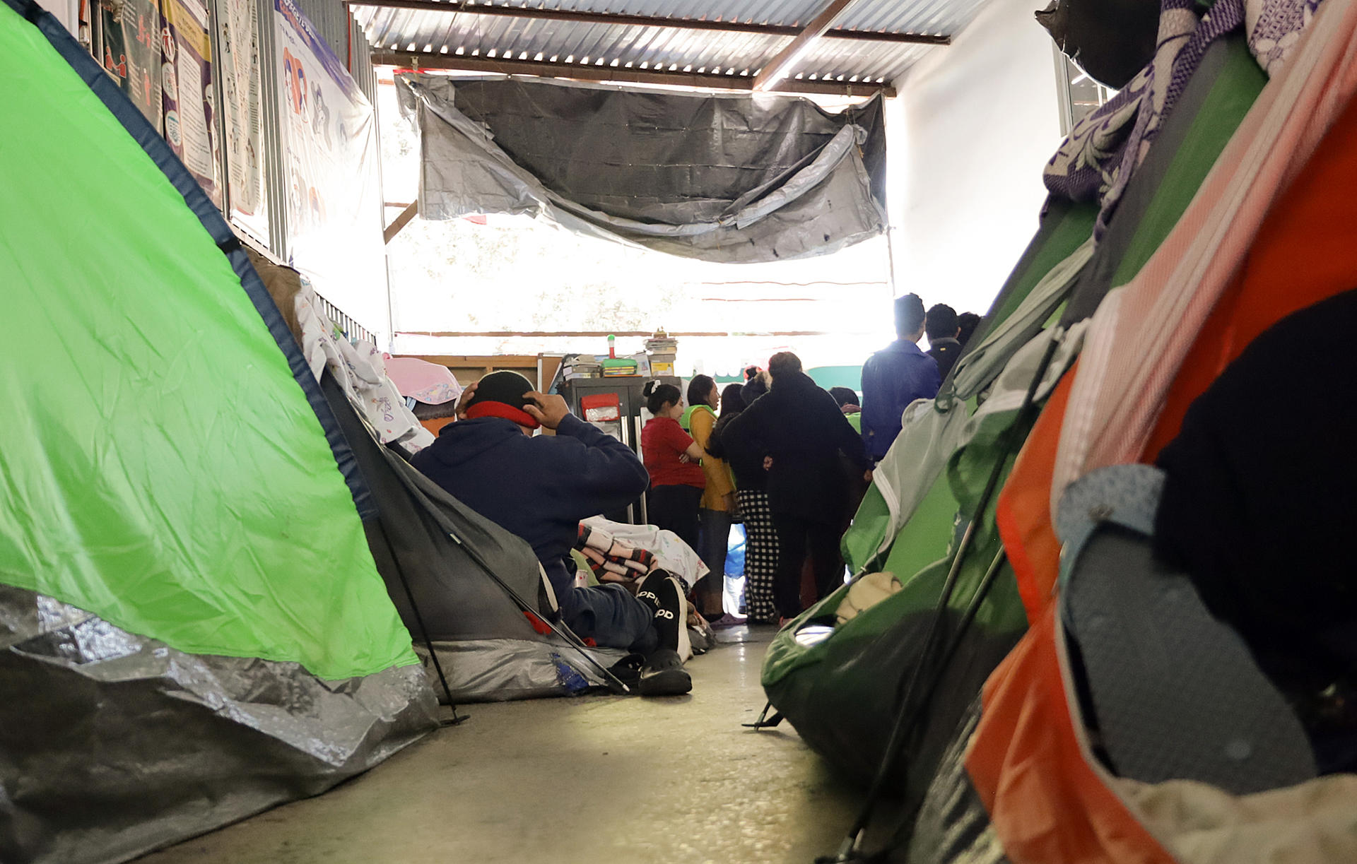 Migrantes descansan en tiendas de campaña en un albergue. EFE/ Joebeth Terríquez