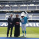 Brett Gosper, director de la NFL en Europa y Asia-Pacífico y Pri Shumate, vicepresidenta de los Miami Dolphins, en el césped del Santiago Bernabéu con la mascota del equipo, durante el acto celebrado este viernes. EFE/ Blanca Millez