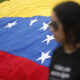 Fotografía de archivo de un mujer junto a una bandera venezolana. EFE/Rodrigo Sura