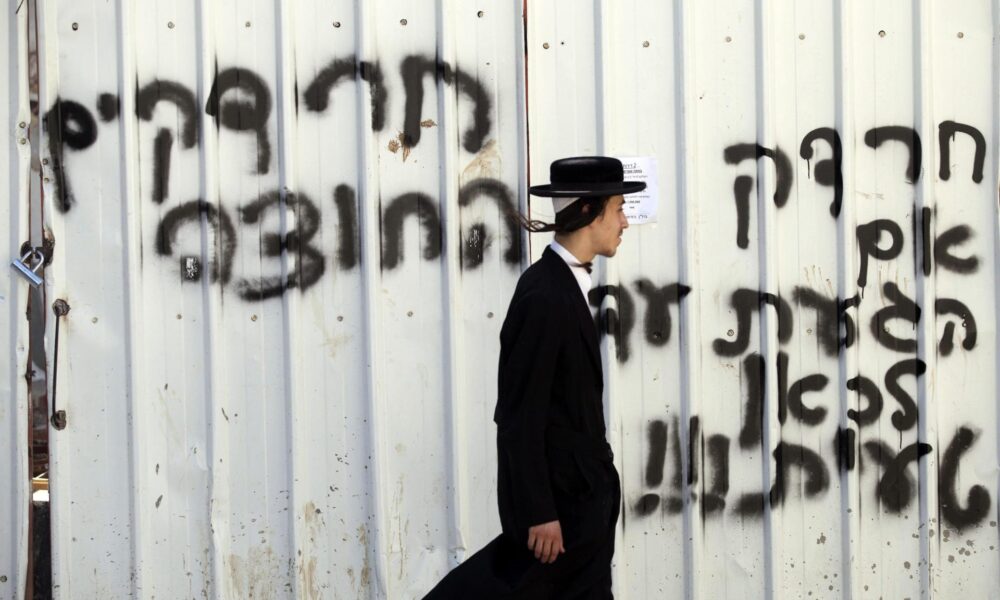 Un judío ultraortodoxo camina frente un grafiti donde está escrito en hebreo "Soldados ultra ortodoxos el 11 de julio de 2013, en el barrio Mea Shearim en el centro de Jerusalén (Israel). Un soldado ultraortodoxo fue atacado el pasado 9 de julio en Jerusalén por una turba de haredím (ultraortodoxos, literalmente, temerosos de dios) contrarios a su incorporación a filas, aprobada recientemente por el Gobierno israelí (Kneset). 
EFE/ABIR SULTAN